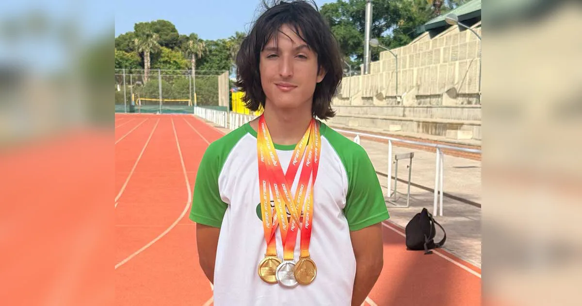 Atleta del Club de Atletismo San Vicente con medallas sobre la pista de atletismo